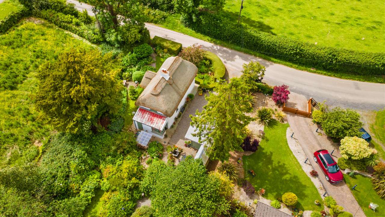 Aerial view of Genista Cottage beside a quiet country road