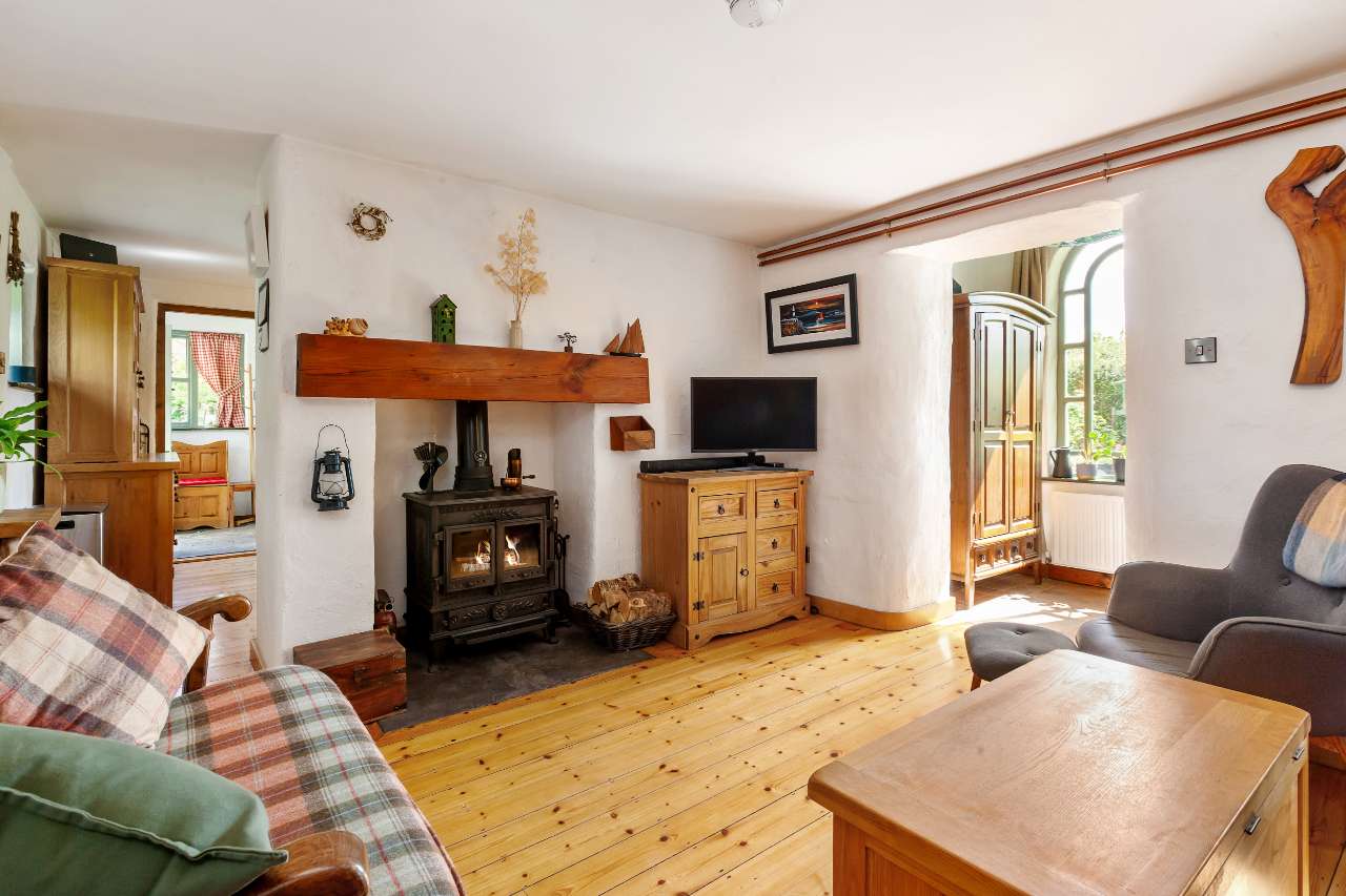 Living room with cast-iron wood-burning stove and timber floor